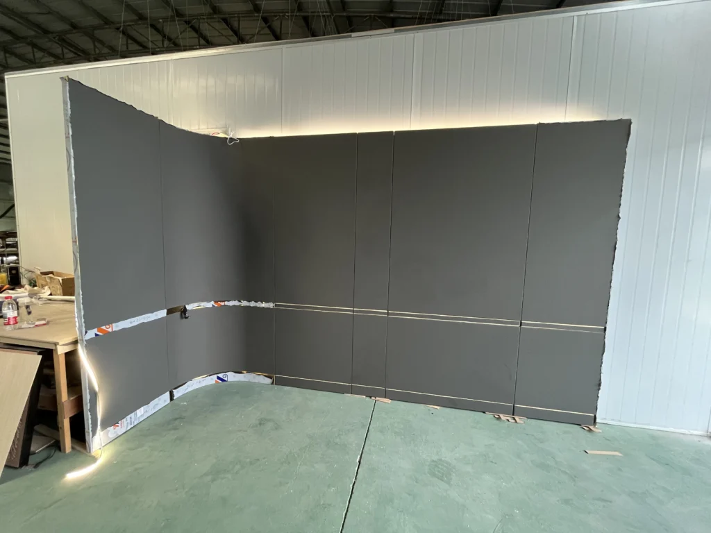 Saipin Decor factory workers applying multi-layered protective packaging to custom upholstered wall panels for international shipping.