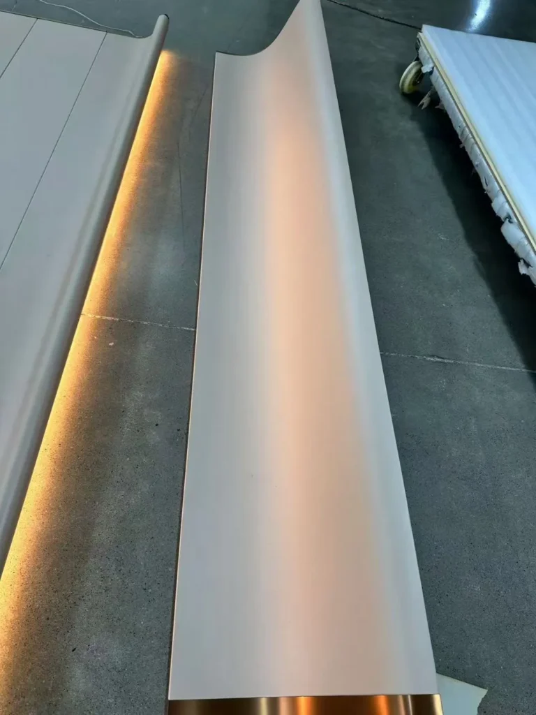 Factory floor assembly of a bespoke curved wall panel with integrated LED backlighting and gold accents by Saipin Decor.