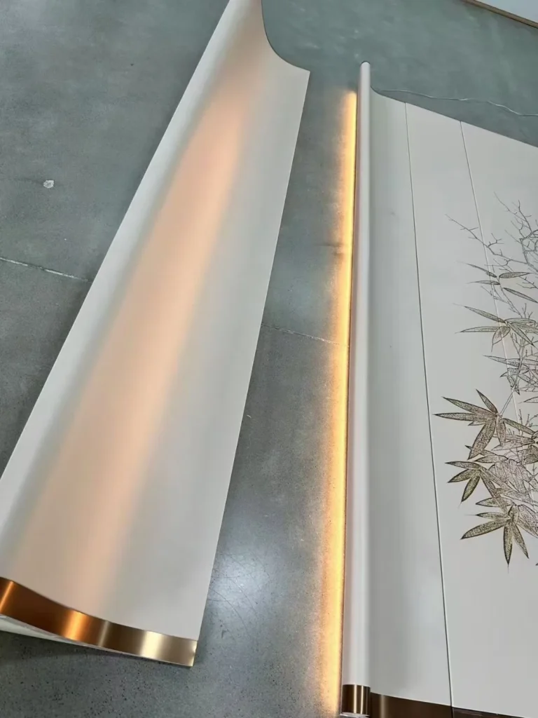 Factory floor assembly of a bespoke curved wall panel with integrated LED backlighting and gold accents by Saipin Decor.